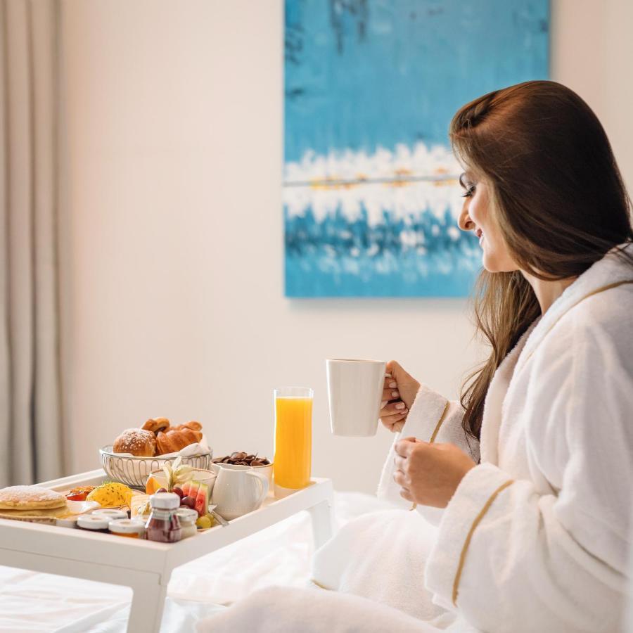 Centara West Bay Hotel & Residences Doha Bagian luar foto A woman in a bathrobe